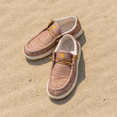 A pair of Camp Shoes sitting in the sand on the beach.