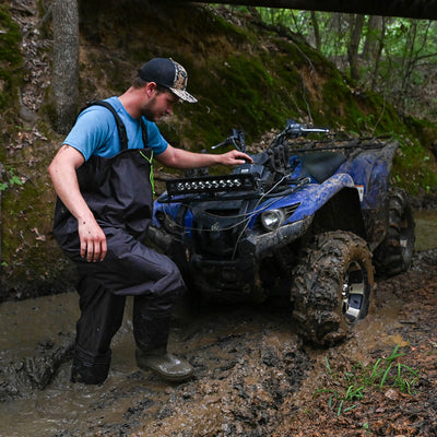 Man climbing out of mud hole in Gator Waders Mudcat Offroad Waders