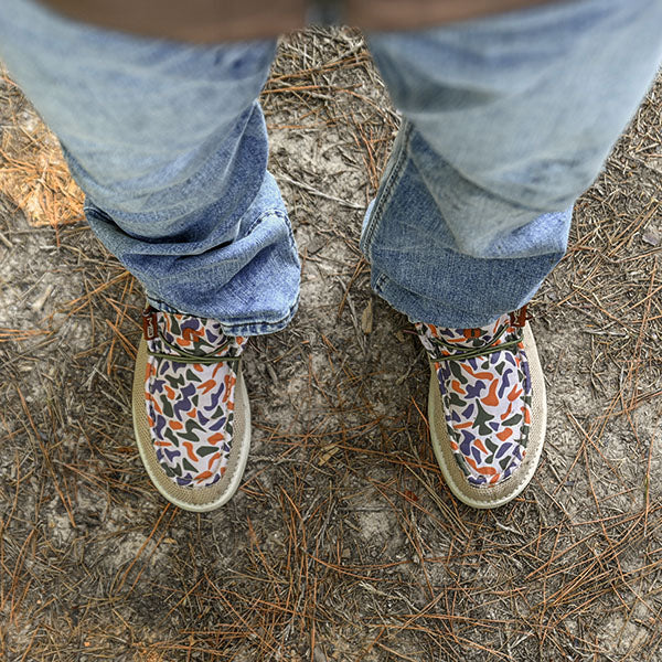 man standing on ground in old school camo camp shoes