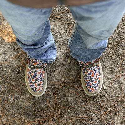 man standing on ground in old school camo camp shoes